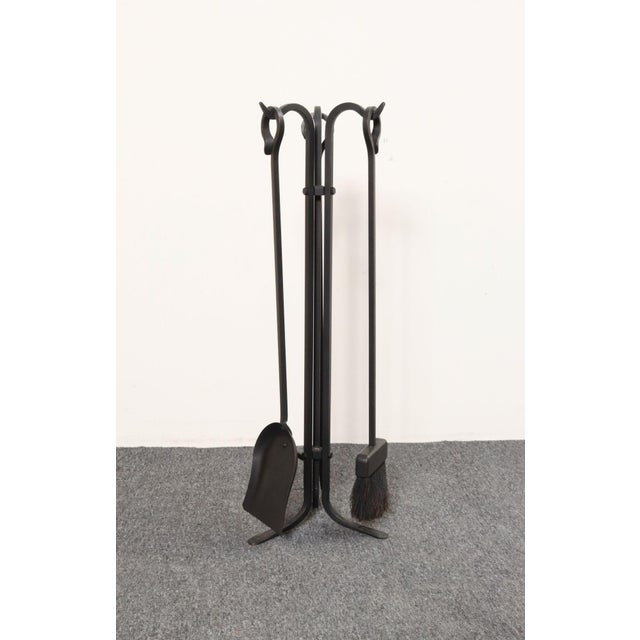 Stylish, minimal set of fire tools with carrier in hand-forged iron (ca. 1970s, USA). Includes the tripod base carrier,...