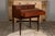 An English mahogany campaign period box on legs from the 19th century revealing a desk with drawers and green felt. This...