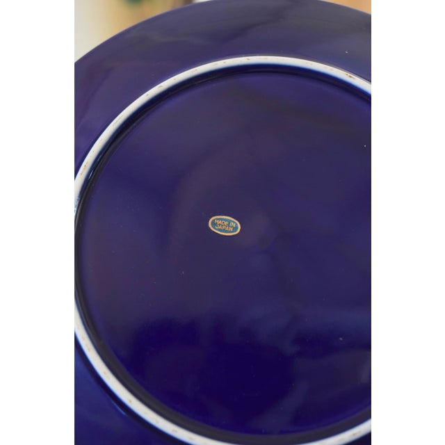 JAPANESE COBALT PORCELAIN PEACOCK PLATE Era: 1970s Origin: Japan Style: Decorative Collector's Plate OVERVIEW: A striking...
