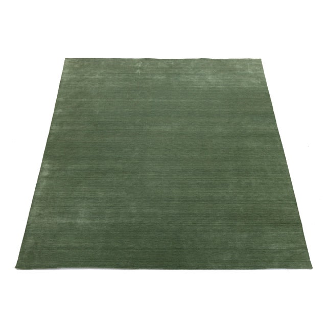 Discover our stunning handcrafted Gabbeh-style wool rug, showcasing a rich Emerald Moss green design. Proudly part of our...