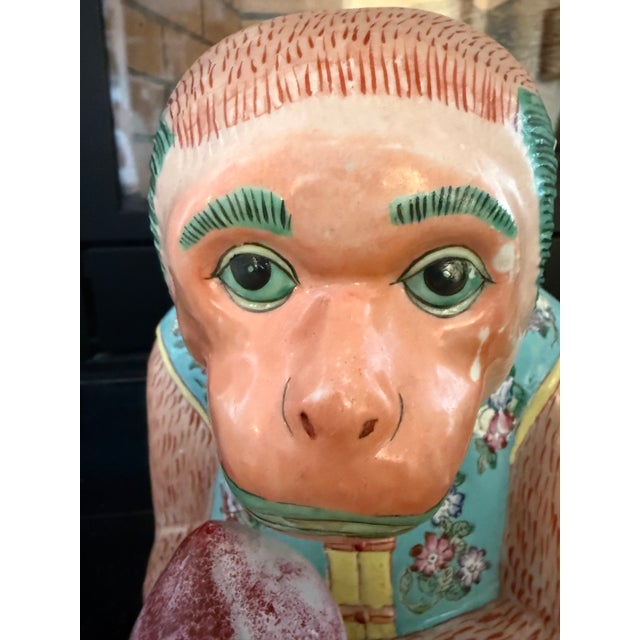 Antique Chinese porcelain monkey holding a peach, beautifully hand-painted in the famille rose export style. Standing an...