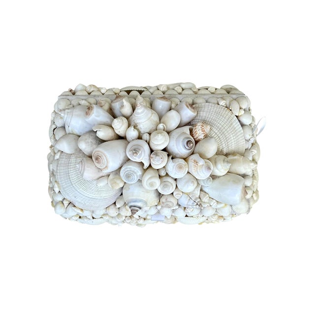 A charming vintage decorative box completely adorned with an intricate arrangement of natural seashells in varying shapes,...