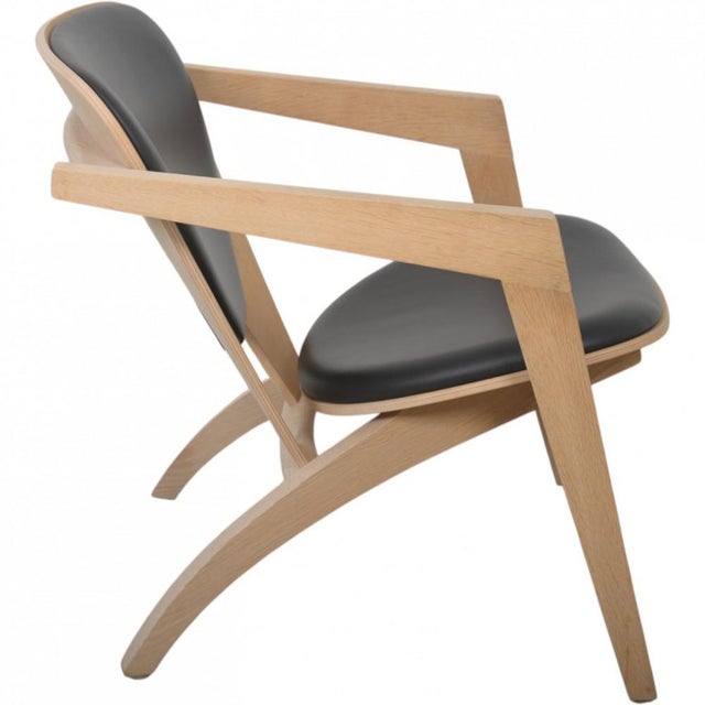 Hans Wegner GE460 Butterfly chair with a frame of oak and back and seat upholstered in black leather. The chair is from...