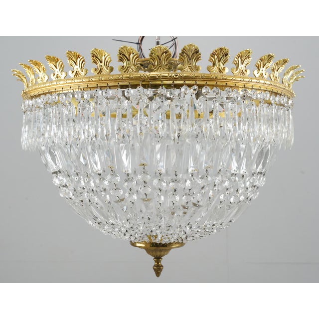 Empire style semi flush mount ceiling light with basket shaped strands of cut crystals and an ornate brass frame and...