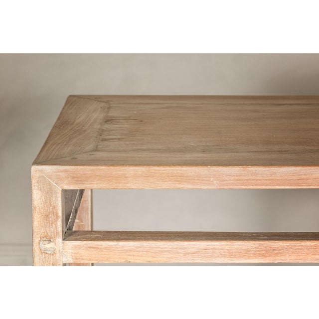 A tall wooden console table with carved beaded rope molding, whitewash natural finish, straight legs and open apron. This...