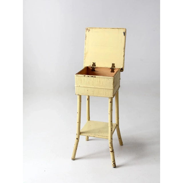 This charming antique painted bamboo side table features a soft pastel yellow finish over woven grasscloth and bamboo....