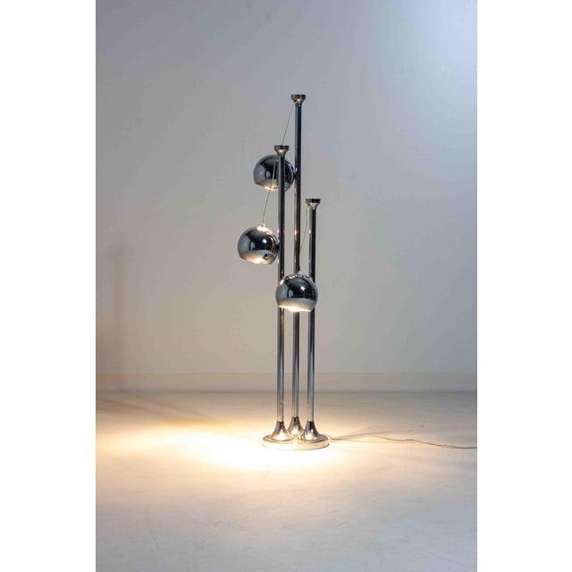 Striking floor lamp in the style of Regianni, Italy, made in the 1970s. The design features three tall chrome stems with...