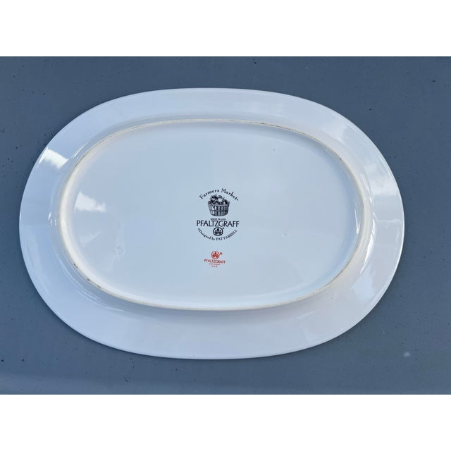 This item is a Pfaltzgraff Farmers Market 14 inch oval serving platter, featuring a black border and vegetable center....