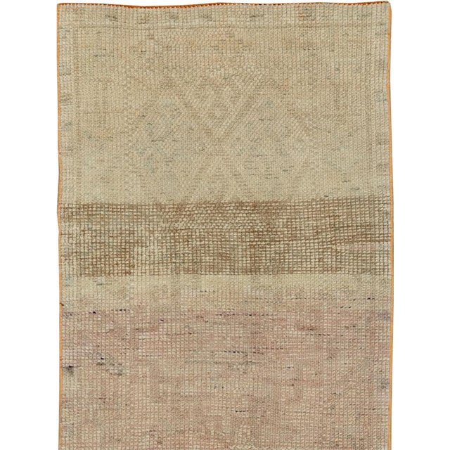 This mid-20th-century Turkish Anatolian runner presents a softly understated composition in muted tones of ivory, sand,...