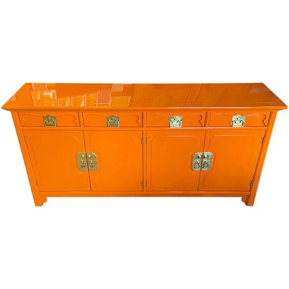 Long rectangular sideboard with a vibrant lacquered orange finish and reflective sheen. Four upper drawers featuring...