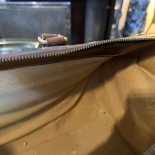 his is a vintage 1970s Gucci bowling bag featuring the brand's iconic brown GG monogram canvas and green-red-green webbing...