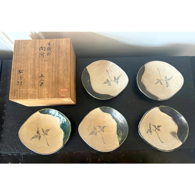 A set of five Japanese ceramic dishes in an inscribed tomobako box. These dishes were made in the types of Ko-Oribe (Old-...