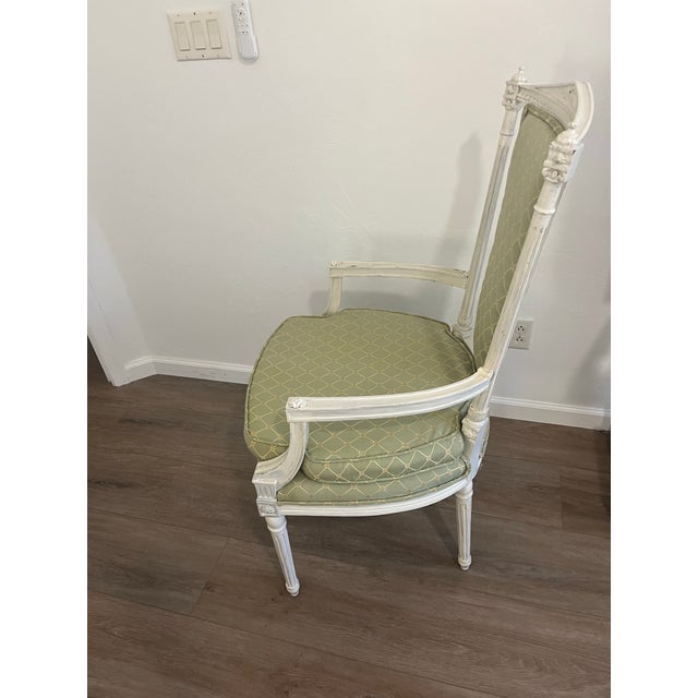 This is a Louis XVI-style armchair, also known as a French Provincial or neoclassical style chair, featuring a painted...