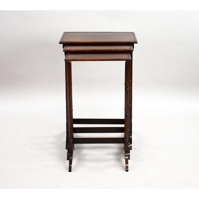 A charming set of three Edwardian mahogany graduated nesting tables, dating to approximately circa 1900–1910. The three...