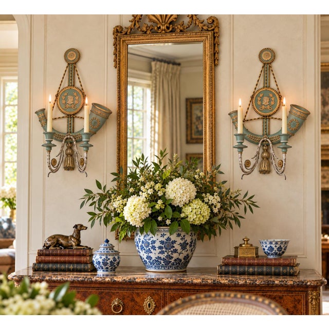A beautifully detailed pair of Italian neoclassical wall sconces featuring a soft celadon green painted finish accented...