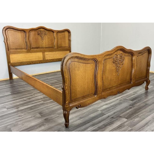 This Vintage French Louis double bed frame showcases elegant carved motifs, flowing shaped panels and a rich oak finish,...