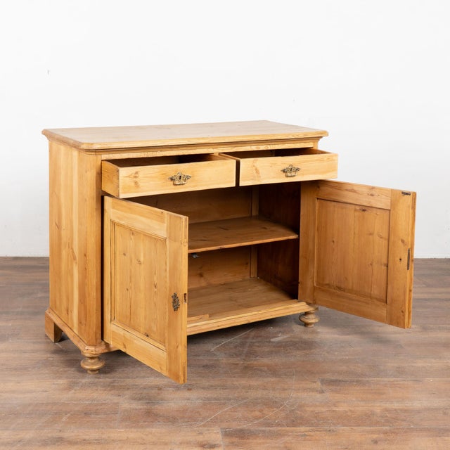 Danish pine sideboard with clean lines; two drawers over two doors, one interior shelf. Restored and waxed, this cabinet...