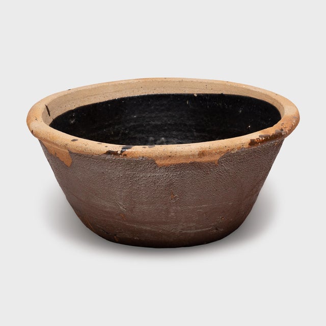 Originally used as a small fish pond, this low ceramic pot from the late 19th century is cloaked in a rich, chocolate-...