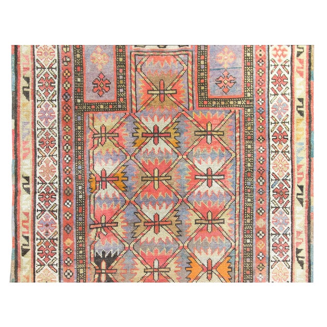 A beautiful early 20th century Persian Kuba prayer rug with a central field covered in stylized flowers and surrounded by...