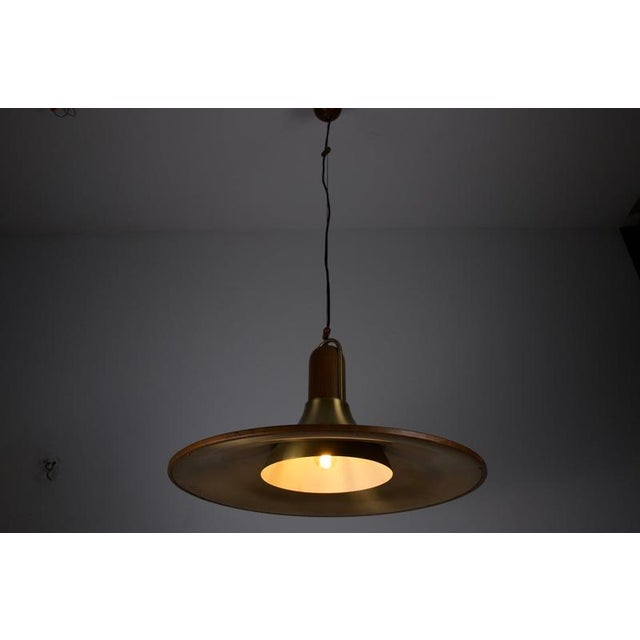 Mid-century teak and brass pendant lamp, italy, 1960s. This distinctive ceiling light combines a wide circular brass shade...