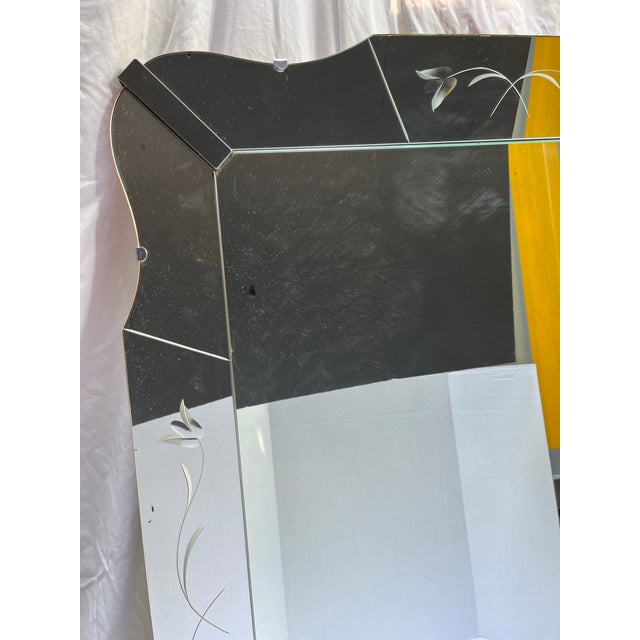A large vintage rectangular wall mirror with pieced and shaped mirror frame with etched floral decoration.