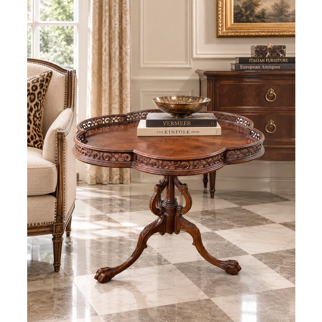 An elegant vintage mahogany occasional table featuring an unusual quatrefoil-shaped top surrounded by a finely pierced...