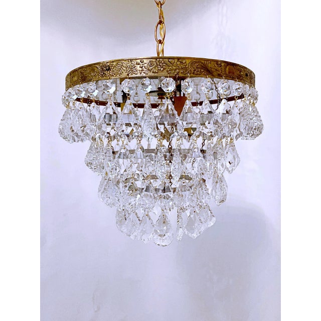 This is an Italian brass rim chandelier dressed with octagon chain and pendeloque cut crystals drops. It has 3 Edison base...