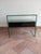 The "Secret" bedside table features a minimalist design and a bridge-shaped structure made entirely of glass. The glass...