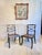 A decorative pair of painted side chairs in the regency taste, likely early 19th century english. The dark green ground...