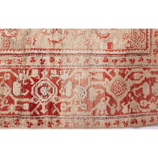 This monumental antique Turkish Oushak rests on a softly mottled ivory-beige field shot through with pale tan abrash,...
