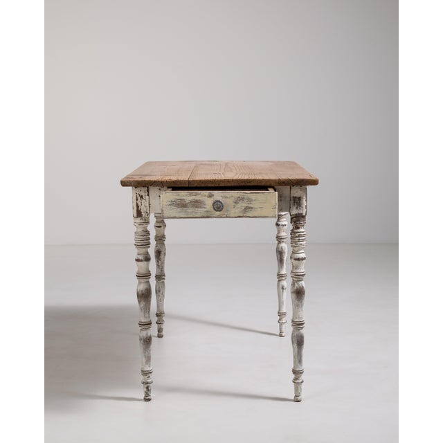 A versatile table featuring a simple design with a functional drawer for storage. The understated construction emphasizes...