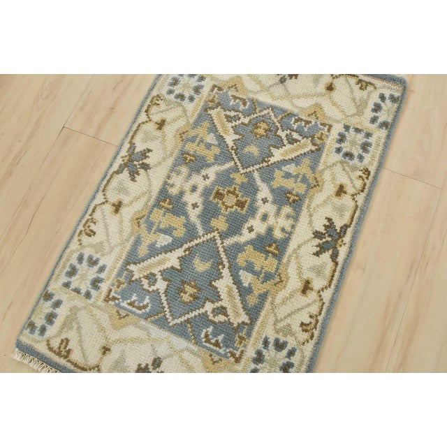 A modern tribal Oushak rug hand-knotted with an all-wool pile on a cotton foundation. This oriental rug features a central...