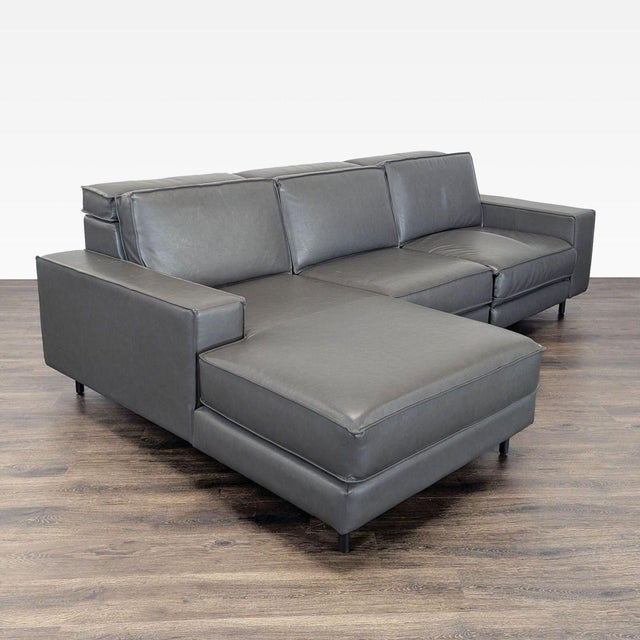 This West Elm sectional offers modern style and comfort with its sleek gray leather upholstery. It features a spacious...