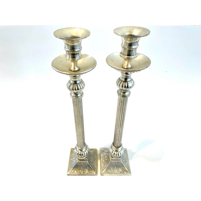 Super decorative pair of neoclassical style silver plated candle holders. Colums, are tall with reeded shaft, heavily...