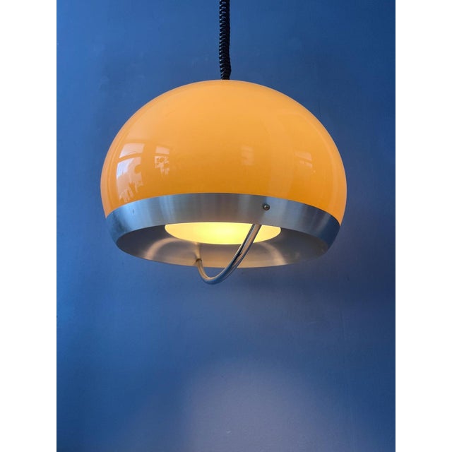 Beautiful Space Age pendant lamp by Dijkstra in a beige/mocca finish with an aluminium and metal frame. The shade emits a...