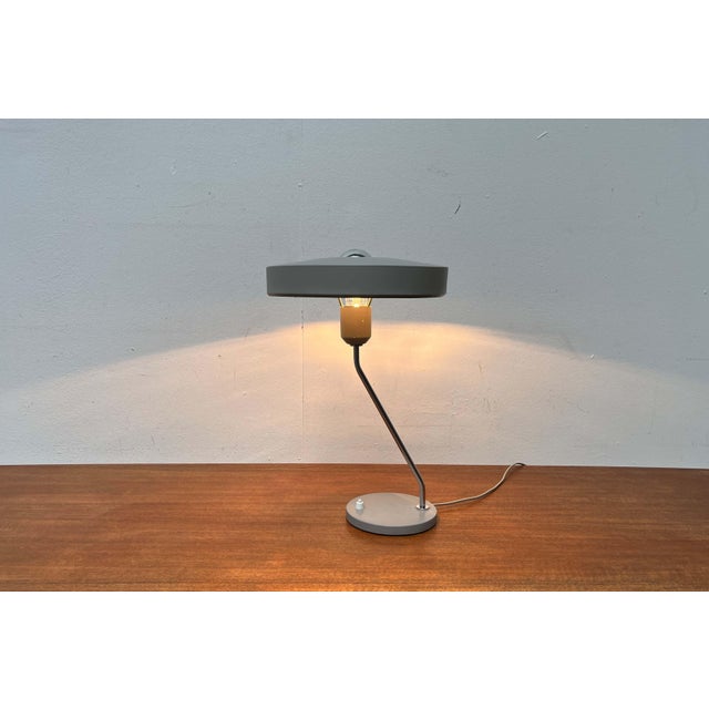 Minimalist table lamp by philips, designed by louis kalff in the 1960s. a minimalist design. The shade has a flat, disc-...