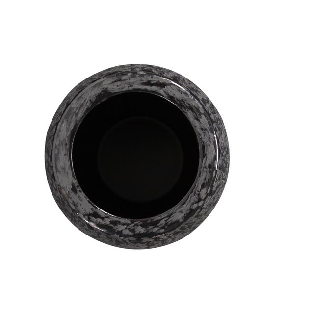 This interesting vase features a glossy black, cylindrical shape formed from iron. What makes it unique, is the chiseled...