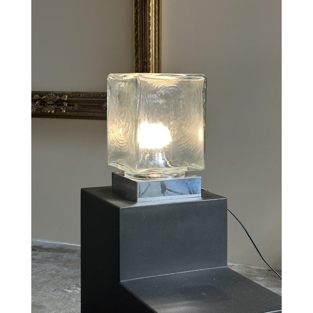 Table lamp, Italian manufacture, 1970s. Square chrome-plated metal base with a side switch, textured glass diffuser with...