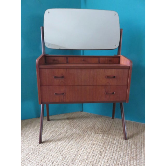 The mirror tilts and is fixed by tightening the screws. It can be removed by dismantling the 2 legs, leaving the drawer...