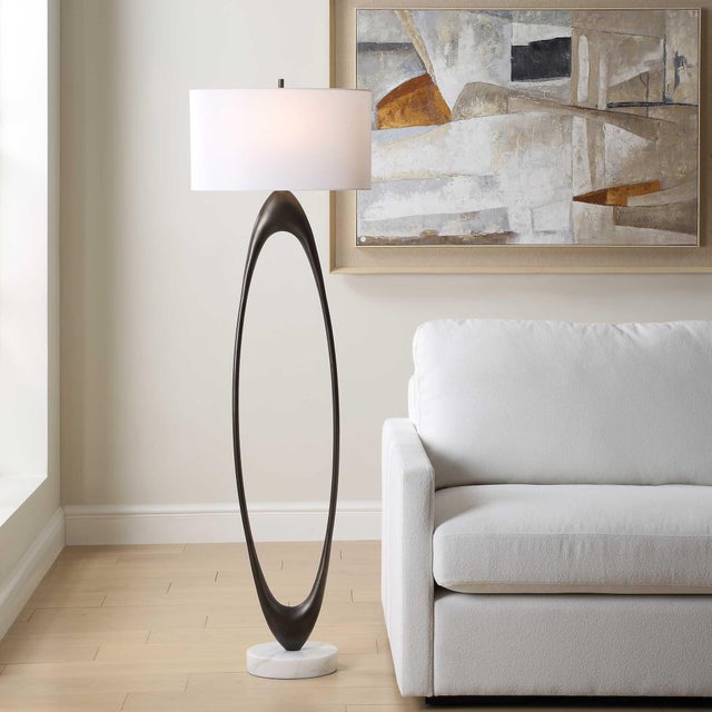 The Elongated, Open Oval Base Is Finished In A Rich Dark Bronze, Resting Elegantly On A Substantial Round White Marble...