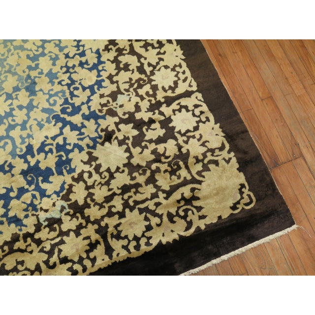 an early 20th Century Chinese rug with a floral design in cream, blue, yellow and brown Measures: 8'11'' x 11'5''.
