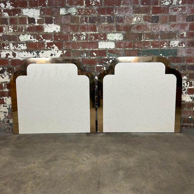 These 1980s cream colored headboards feature classic Moroccan shaped arches with a thick band of reflective rose gold trim.