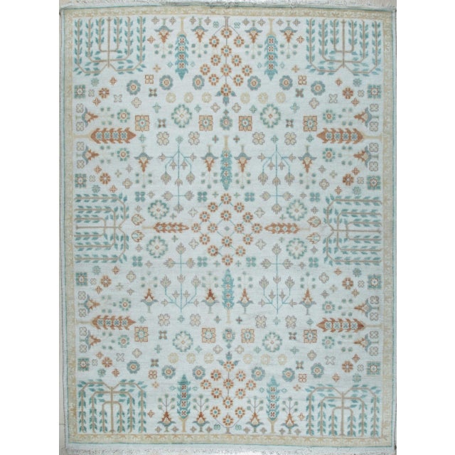 A hand-knotted wool Oushak, made in India and measuring 8' x 10'. Oushak weaving is known for large-scale, softly drawn...