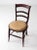 An elegant 19th century wood chair. The dark wood chair features turned legs, ladder back, and round upholstered seat. The...