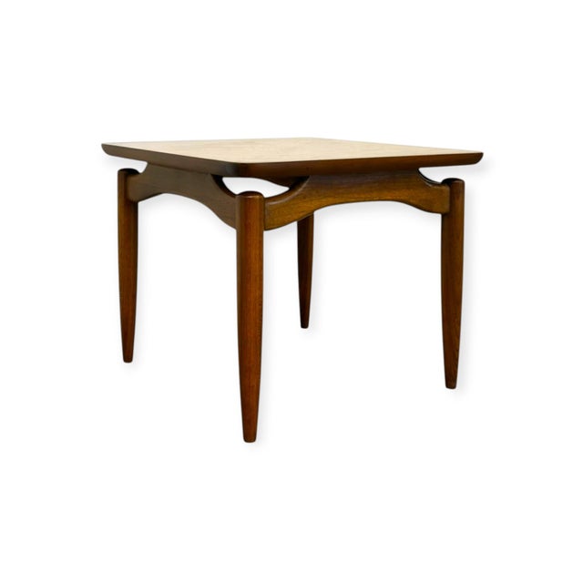 This mid-century modern square end table features a rich wood finish with prominent natural grain patterns across its...