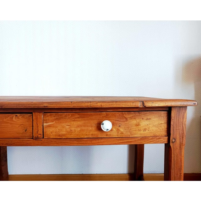Solid wood farmhouse desk or table. Two drawers on the front with white ceramic knobs featuring holes in the glaze in an...