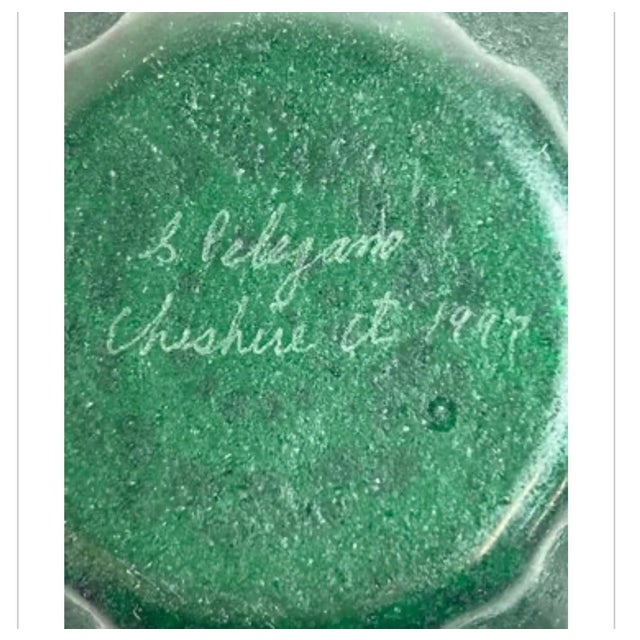 This exquisite hand-blown emerald green art glass bowl features a ruffled rim and intricate lace overlay pattern that...