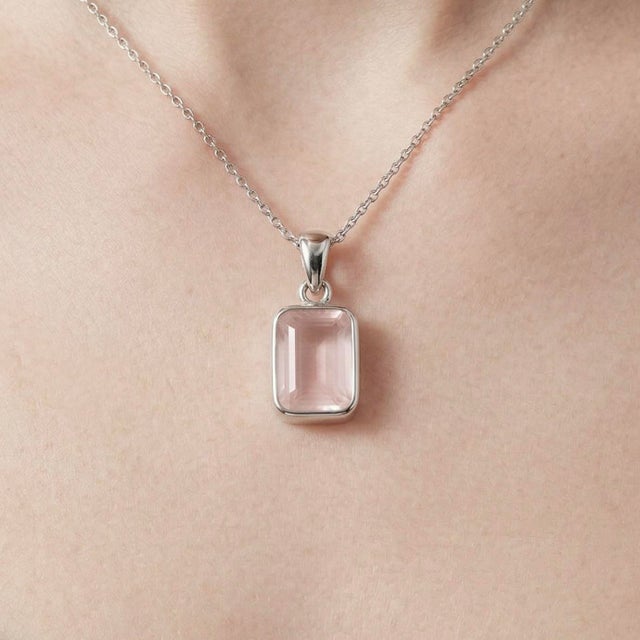 This elegant pendant features a soft and luminous Rose Quartz gemstone, cherished for its delicate blush-pink hue and...