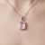 This elegant pendant features a soft and luminous Rose Quartz gemstone, cherished for its delicate blush-pink hue and...