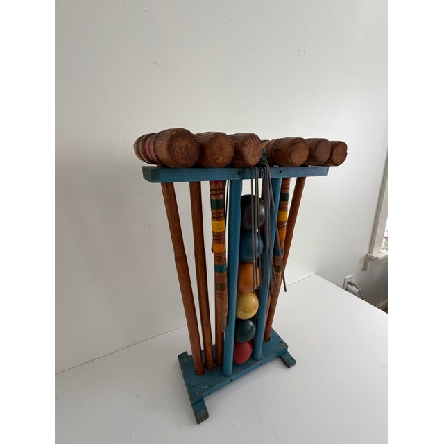 Complete vintage six-player croquet set featuring six turned hardwood mallets, six painted wooden balls, metal wickets,...